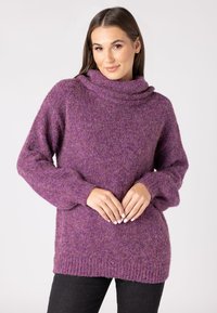Maglione lavorato a maglia viola con collo a cascata, maniche lunghe e orlo a coste. Il materiale appare morbido e caldo.