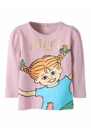 Różowa koszulka z długim rękawem z postacią z kreskówki o pomarańczowych włosach w warkoczach, z napisem "PIPPI" w błyszczącym złocie oraz kolorowymi akcentami w odcieniach niebieskiego i zielonego.
