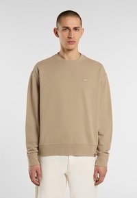 Beige sweatshirt met een ronde halslijn, lange mouwen en ribgebreide boorden. Beschikt over een klein logolabel op de borst en een relaxte pasvorm.