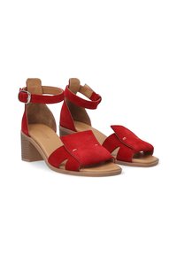 Rode suède sandalen met een open teen ontwerp, enkelband en blokhak. Voorzien van een gelaagde voorband met decoratieve metalen accenten.