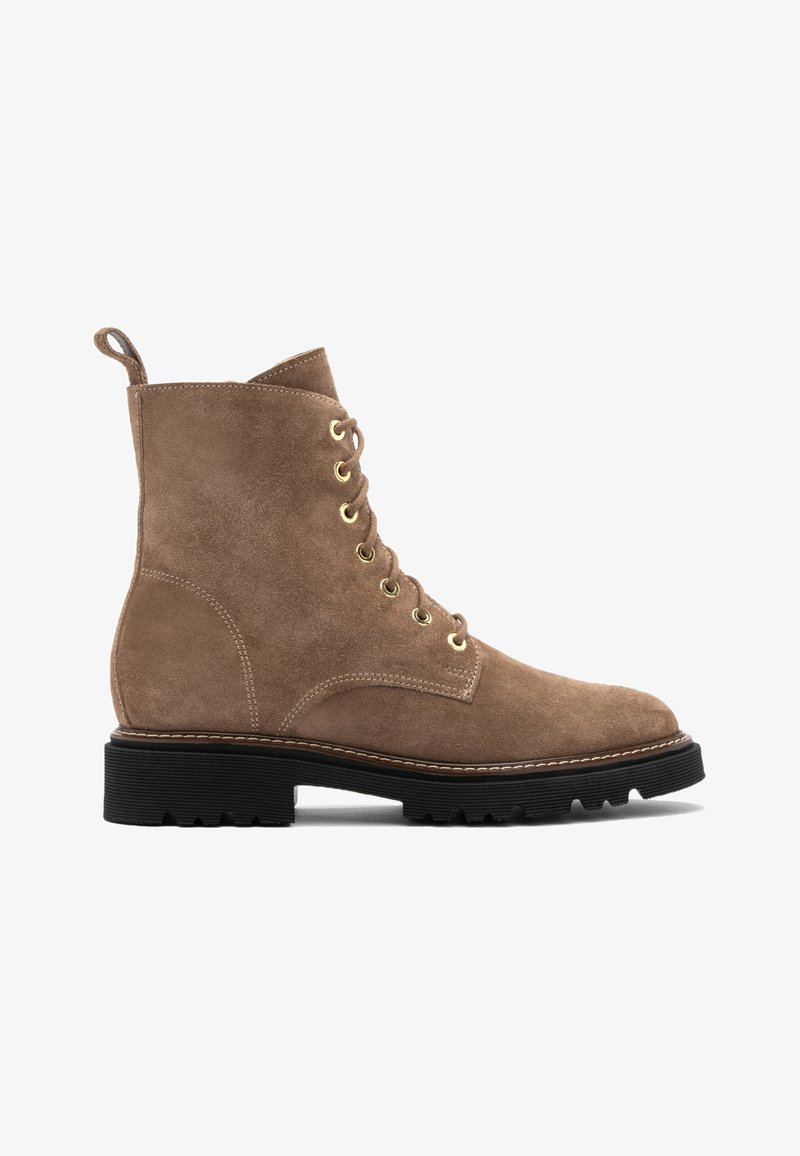Bottine en daim marron clair à lacets, œillets dorés, languette au talon et semelle épaisse en caoutchouc noir à crampons.