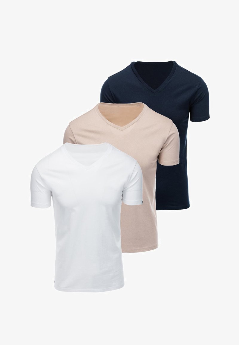 Trois t-shirts unis à col en V, manches courtes, en blanc, beige et bleu foncé, présentés en couches sur un fond blanc.