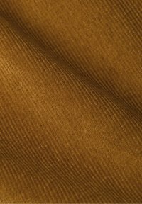 Tekstuuri kangas sooja kuldpruuni tooniga, mis sisaldab soonelisi mustreid. Pind on pehme ja kudumise välimusega ning sisaldab peeneid variatsioone.