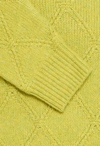 Strickpullover in Hellgelb mit einem Rautenmuster und gerippten Bündchen. Weiche Textur mit einem leicht lockeren Strick.