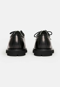 Scarpe in pelle nera con finitura liscia, punta tonda, design con lacci e suole in gomma spessa con battistrada profondo per una migliore aderenza.