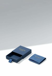 Blå smyckeslåda med utdragbar låda och matchande mjuk påse, båda märkta med "Sif Jakobs Jewellery Copenhagen" i guldfärgade bokstäver.