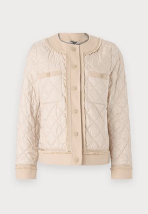 Beige tikandatud jakk ümmarguse kraega, kahe esikuvahemikuga ja nööpidega kinnitusega. Pehme tekstuur kontrastsete ääristuste detailidega.