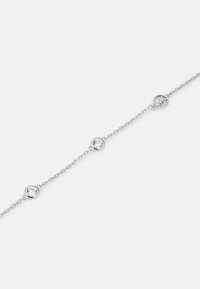 Bracciale in argento con tre pietre rotonde trasparenti in montature circolari e un charm con logo, che mette in mostra un design delicato e minimalista.