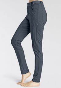 Sivé, elastické nohavice so slim fit strihom, s bočnými vreckami na zips a hladkou textúrou. Navrhnuté s moderným zúžením.