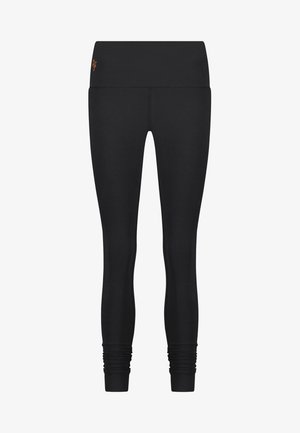Schwarze Leggings aus dehnbarem Material mit hohem Taillenbund und gerafften Knöchel-Details. Subtle orangefarbener Logo-Akzent am Taillenbund.