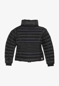 Schwarze Daunenjacke mit hohem Kragen, ausgestattet mit gesteppten Einsätzen, elastischen Bündchen und einem runden Logo auf der unteren linken Seite.