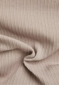 Tessuto a costine di un beige chiaro, con una consistenza morbida e una notevole elasticità, caratterizzato da sottili linee verticali e cuciture lisce.