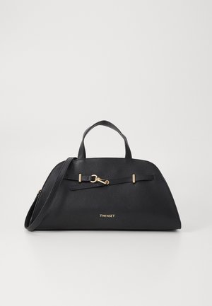 Black leather handbag with a curved shape, gold hardware accents, a detachable strap, and a front logo. Textured finish.