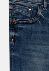 Džínové kalhoty s tmavým praním, s měděnými detaily a malým srdíčkovým akcentem na přední kapse. Jemná textura a detail šití.