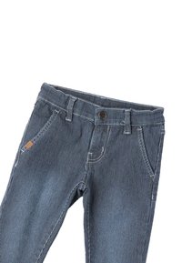 Pantalones vaqueros de mezclilla a rayas azules y blancas con un diseño ajustado, cinco bolsillos y un cierre de botón negro en la cintura.