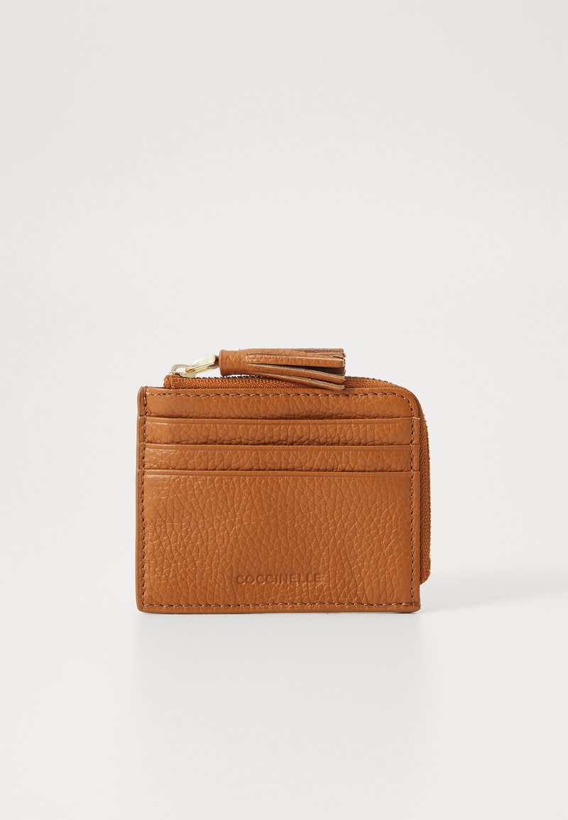 Porta-cartões de couro castanho claro com textura, apresentando múltiplos slots para cartões e um compartimento com fecho, realçado por uma pequena borla.