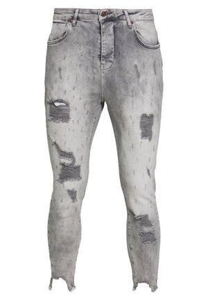 Graue Skinny-Jeans im Used-Look mit zerrissenen Stellen an Oberschenkeln und Knien, ausgefransten Säumen und klassischem Fünf-Taschen-Design.