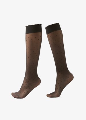 Calcetines negros transparentes hasta la rodilla con pequeños lunares y una banda negra sólida en la parte superior, mostrados en el pie izquierdo y derecho.