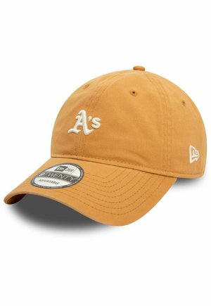 Baseballkappe aus goldenem Stoff mit weißem gesticktem "A's"-Logo. Verfügt über einen gebogenen Schirm, ein verstellbares Band und eine strukturierte Krone mit Belüftungsöffnungen.