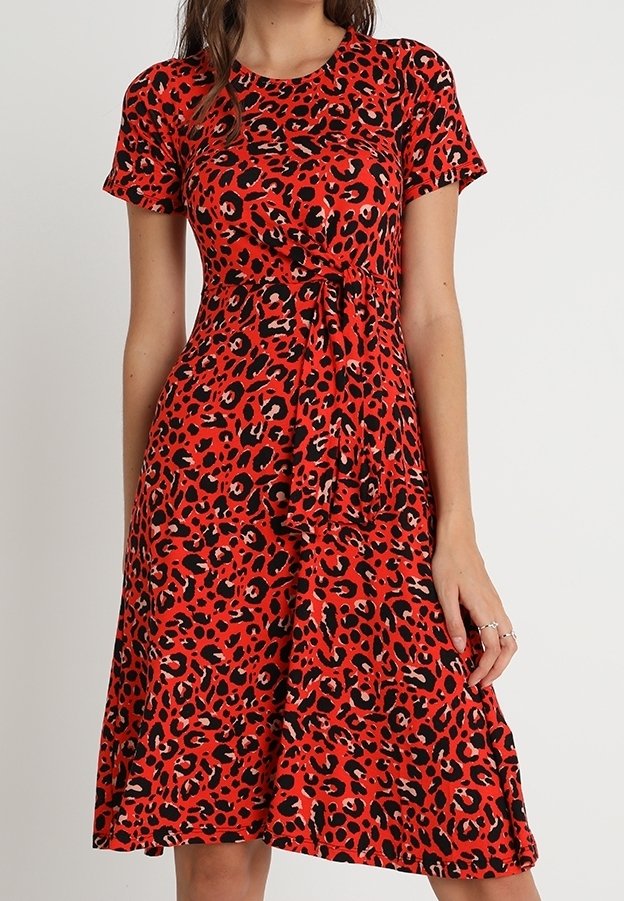 Punainen leopardi-kuosiset mekko lyhyillä hihoilla, istuva bodice ja levenevä hame. Valmistettu pehmeästä kankaasta, jossa on vyöllinen yksityiskohta.