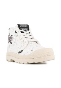 Baskets montantes blanches en matériau texturé avec un motif moucheté. Présentent des accents noirs, des lacets et un logo bien en vue sur la languette.