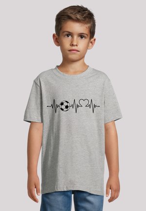 Gray cotton t-shirt featuring a black graphic of a soccer ball integrated with a heartbeat line and heart symbol. Short sleeves, relaxed fit.