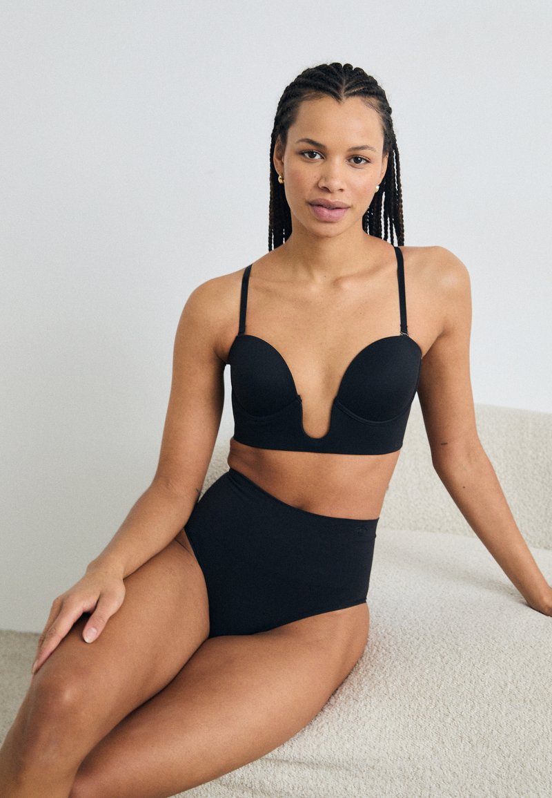 Black lingerie set featuring a plunge bra with molded cups and adjustable straps, paired with high-waisted briefs in a smooth fabric.