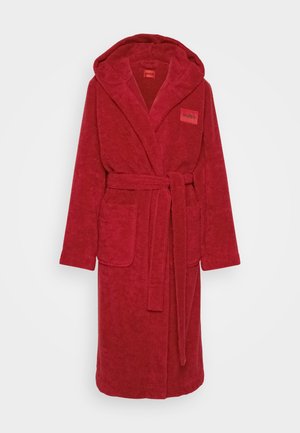 Vörös pamut fürdőköpeny kapucnival, megkötő övvel, két elöl található zsebből és egy logóval a bal felső oldalon. Puha tapintású és hosszú ujjú.