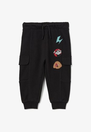 Zwarte sweatpants met een elastische tailleband, voorzien van drie kleurrijke geborduurde patches: een bliksemflits, een figuur en een beer.