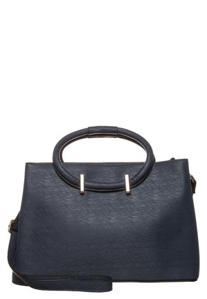 Sac à main structuré bleu foncé avec poignées rondes et bandoulière amovible, orné de pièces métalliques dorées sur fond blanc.