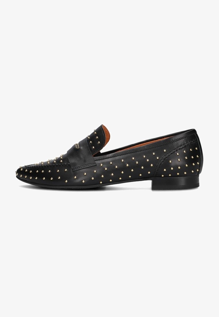 Mocassins noirs en cuir avec des clous dorés, semelle plate et une bride décorative au milieu. Texture lisse avec des accents ronds cloutés.
