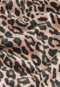 Material cu model leopard în nuanțe de bej și negru, cu o textură moale, având pete întunecate proeminente și ploi netede, fluide.