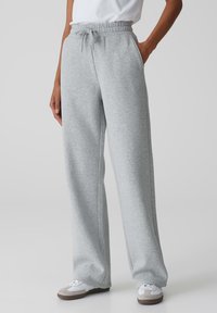 Lichtgrijze sweatpants met een relaxte pasvorm, elastische tailleband, trekkoord, zijzakken en taps toegevouwen cuffs. Gemaakt van een zachte katoenmix.