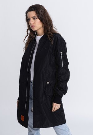 Black bomber jacket made of lightweight fabric, features a front zip, ribbed cuffs, and a side pocket with a zipper. Ideal for casual wear.