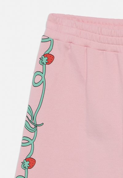 Rózsaszín szövetnadrág zöld szőlő és piros eper mintával az oldalon, rugalmas derékpánttal a felső részen.