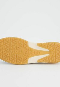 Suela de zapato de goma con un patrón texturizado en zigzag; color marrón claro con el texto "paul green" en relieve; características de agarre en forma de triángulo para tracción.