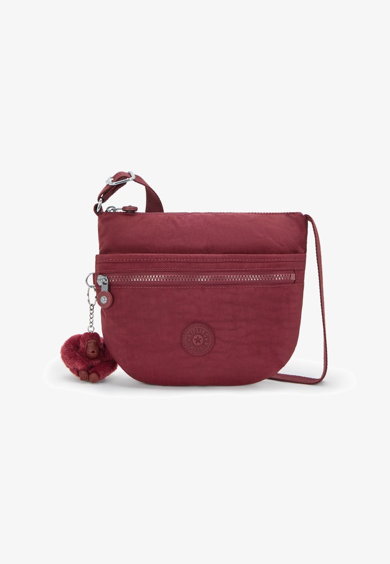 Borsa a tracolla bordeaux realizzata in tessuto resistente, con una tasca con zip, un logo circolare e un portachiavi a forma di scimmietta in peluches.
