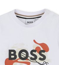 T-shirt en coton blanc avec un col rond aux rayures contrastantes. Affiche un texte noir en gras "BOSS" et des éléments graphiques abstraits rouges.