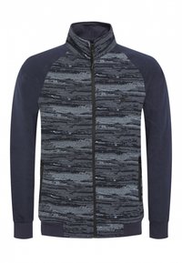 Giacca con zip caratterizzata da una parte superiore a motivi grigia e nera, maniche blu scuro e polsini solidi. Tessuto morbido con tasche laterali.