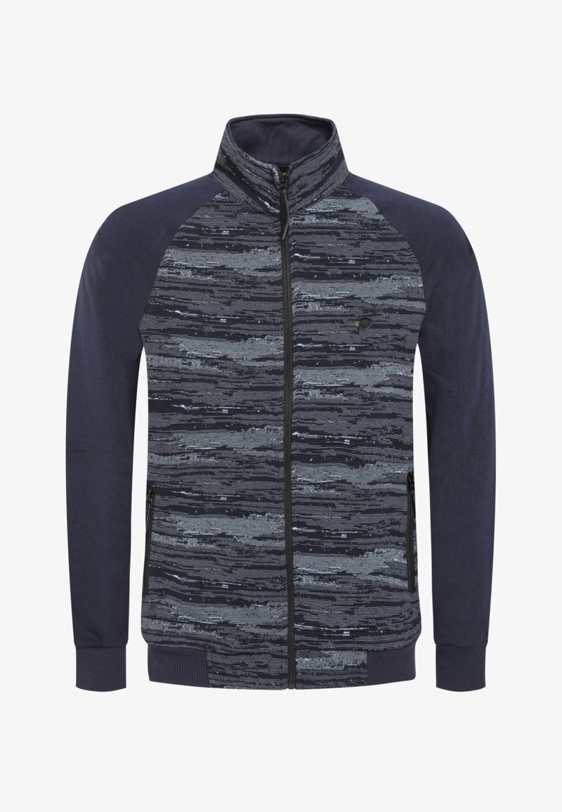 Giacca con zip caratterizzata da una parte superiore a motivi grigia e nera, maniche blu scuro e polsini solidi. Tessuto morbido con tasche laterali.