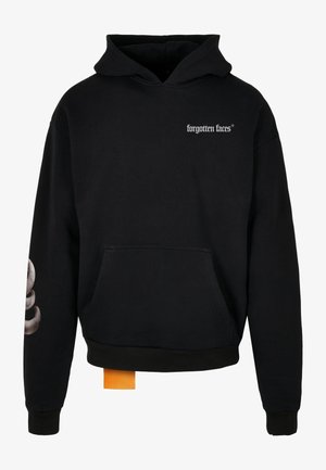 Čierna mikina s kapucňou a prednou kapsou, biele logo na hrudi a grafický detail na rukáve. Obsahuje oranžovú nášivku na dolnom okraji.