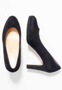 Marina blå mocka högklackade skor med en slät yta, rund tå och glittriga svarta klackdetaljer. Snygg design, inga synliga mönster.