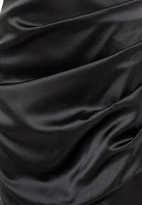 Schwarzer Satin-Stoff mit weichen, fließenden Falten und einer glatten, glänzenden Textur, die Licht reflektiert.