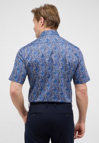Korte mouw shirt in blauw met een bladerenpatroon, voorzien van een puntige kraag en een rechte snit. Het materiaal lijkt glad met een subtiele glans.