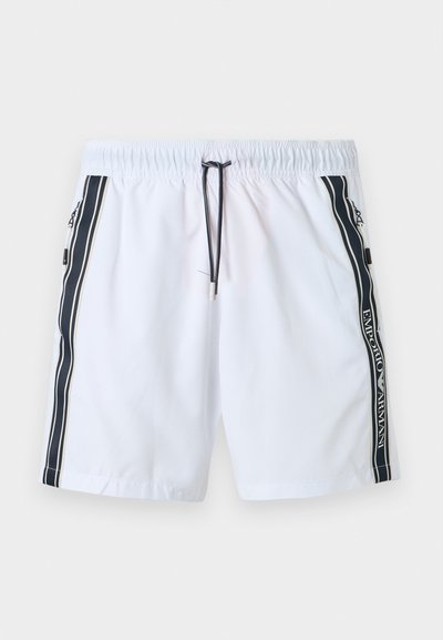 Λευκά μαγιό σορτς με μαύρο κορδόνι, μαύρες πλαϊνές ρίγες με το κείμενο "EMPORIO ARMANI" και τσέπες με φερμουάρ σε κάθε πλευρά.