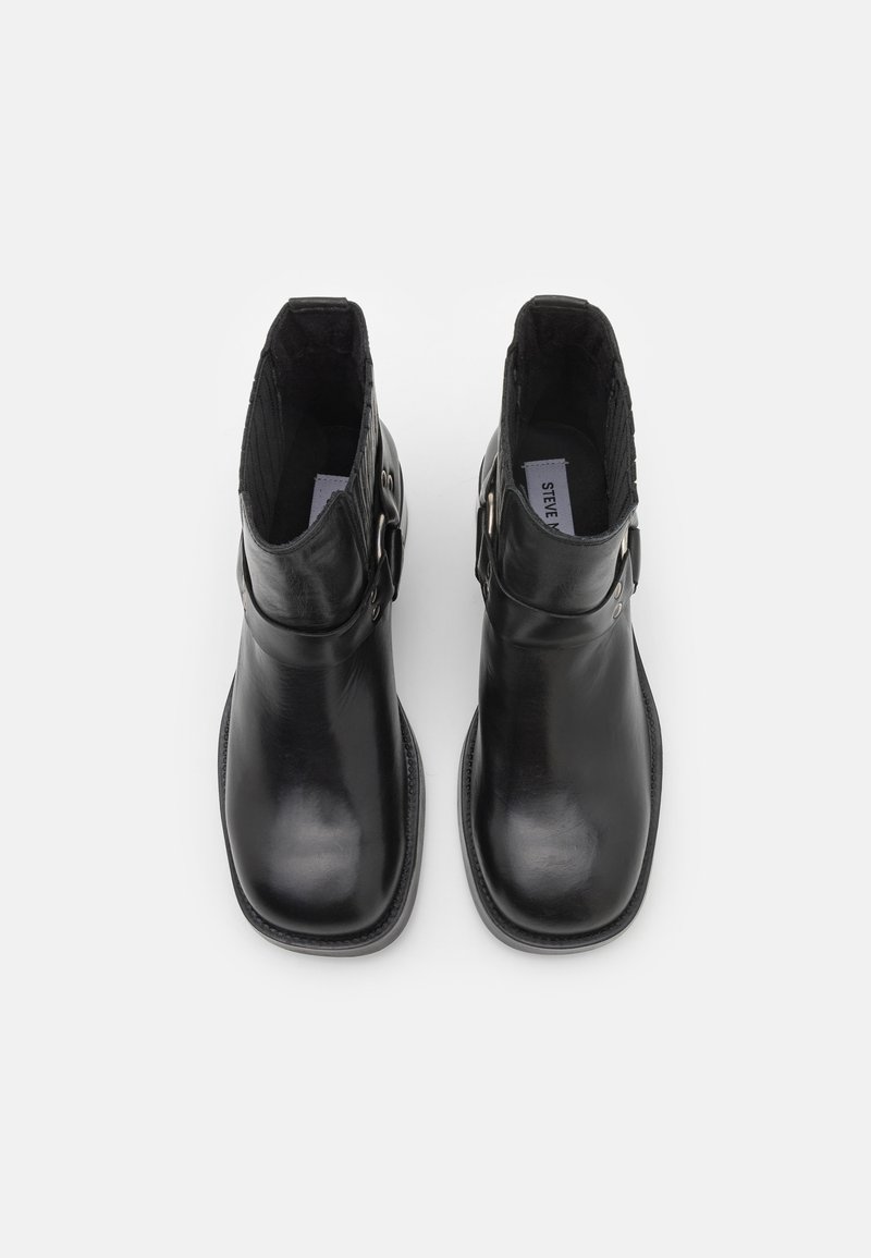 Schwarze Leder Stiefeletten mit glatter Oberfläche, runder Zehenpartie und Schnallenakzent an der Seite. Das Innere verfügt über eine weiche Fütterung.