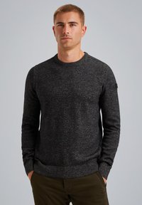 Schwarzer gestrickter Pullover mit langen Ärmeln, rundem Halsausschnitt und subtiler melierter Textur. Verfügt über ein kleines Logopatch am Ärmel.