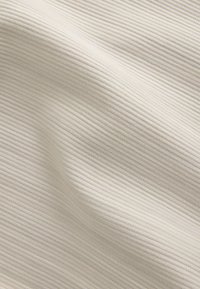 Ljusbeige tyg med en fin ribbad textur, som visar horisontella linjer och en mjuk, slät yta. Inga synliga mönster eller accenter.