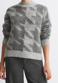 Gray knitted sweater with a geometric pattern in varying shades of gray. Features a crew neck and ribbed cuffs, made from a soft, textured material.