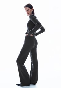 Grau meliertes, geripptes Strick-Zweiteiler-Outfit mit einem eng anliegenden Langarmoberteil und ausgestellten Hosen mit glatter Textur und dezielter Elastizität.